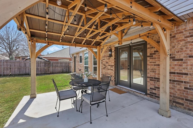 view of patio / terrace featuring french doors, outdoor dining space, and fence