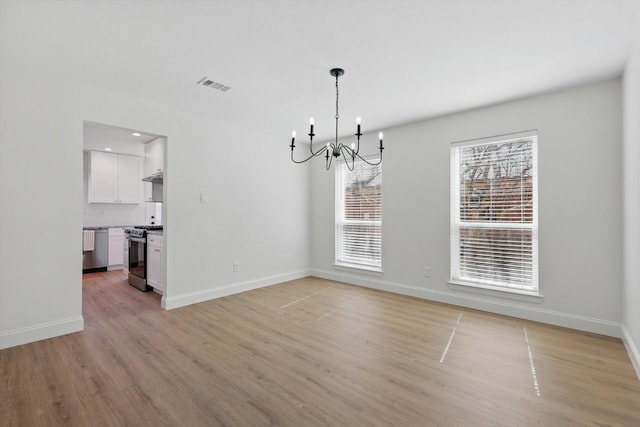 unfurnished dining area featuring a chandelier, baseboards, visible vents, and light wood finished floors