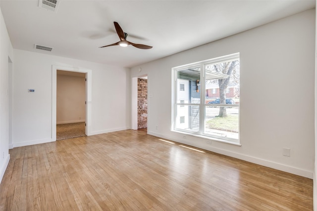 spare room with light wood-style floors, visible vents, and a ceiling fan