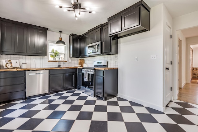 kitchen with stainless steel appliances, light floors, wood counters, and decorative backsplash