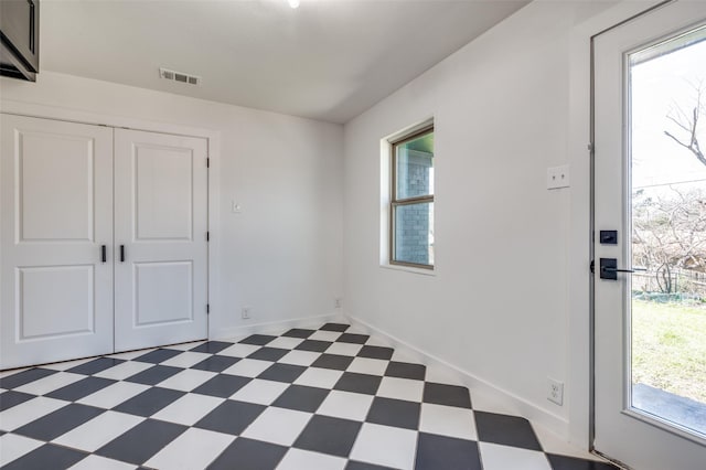 unfurnished room featuring baseboards, visible vents, and tile patterned floors