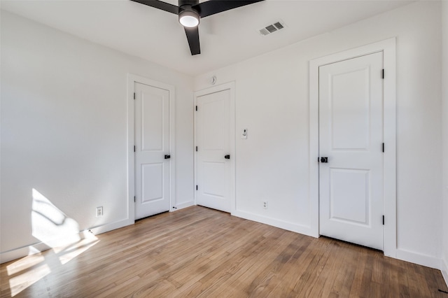 unfurnished bedroom with light wood finished floors, baseboards, visible vents, and ceiling fan