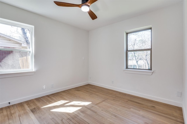 empty room featuring a ceiling fan, baseboards, and wood finished floors