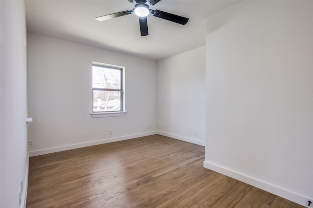 unfurnished room with wood finished floors, a ceiling fan, and baseboards