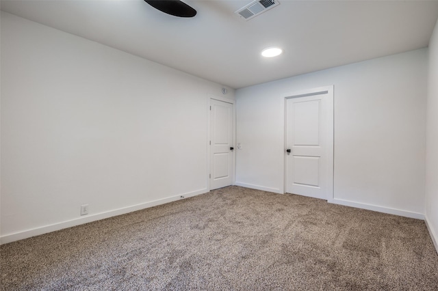 carpeted spare room featuring visible vents and baseboards