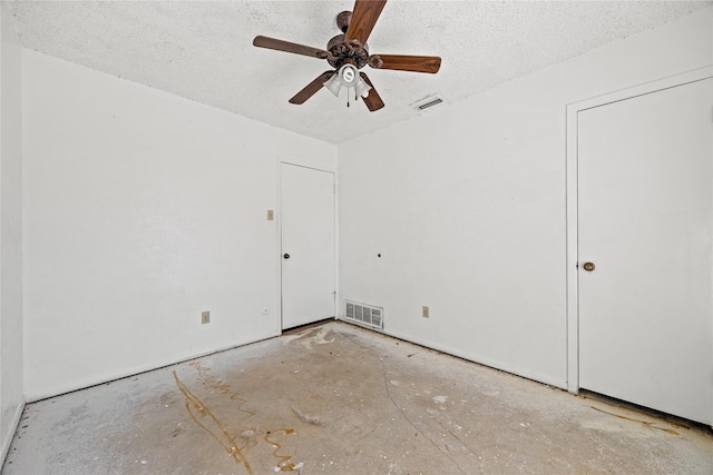 unfurnished room featuring a ceiling fan, visible vents, and a textured ceiling