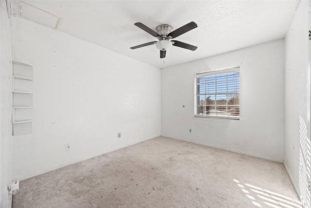 spare room featuring a textured ceiling, a ceiling fan, and light colored carpet