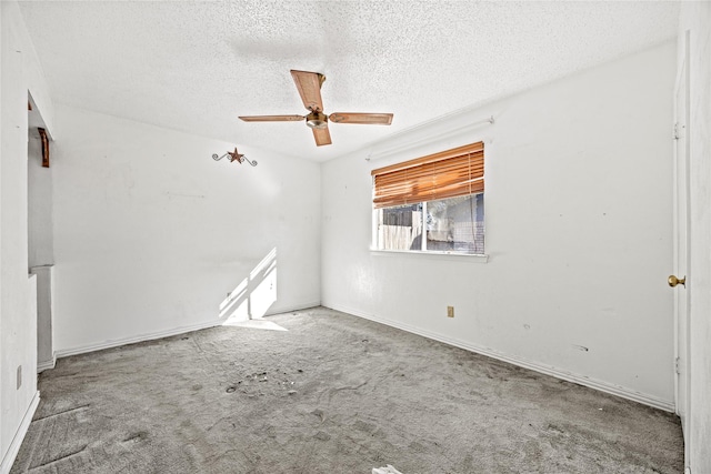 carpeted spare room with ceiling fan, baseboards, and a textured ceiling