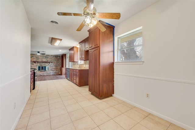 kitchen featuring a fireplace, visible vents, a ceiling fan, light countertops, and stainless steel dishwasher