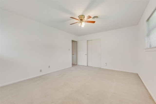 unfurnished bedroom with light carpet, baseboards, visible vents, ceiling fan, and a closet