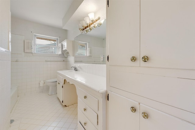 bathroom with toilet, tile patterned flooring, vanity, and tile walls