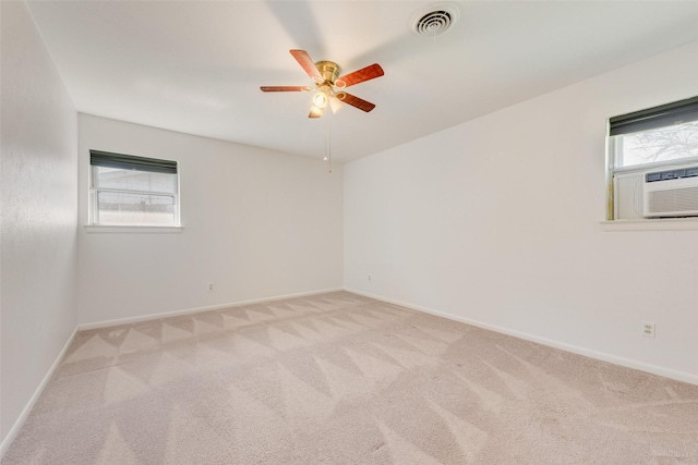 unfurnished room featuring light carpet, cooling unit, visible vents, and baseboards