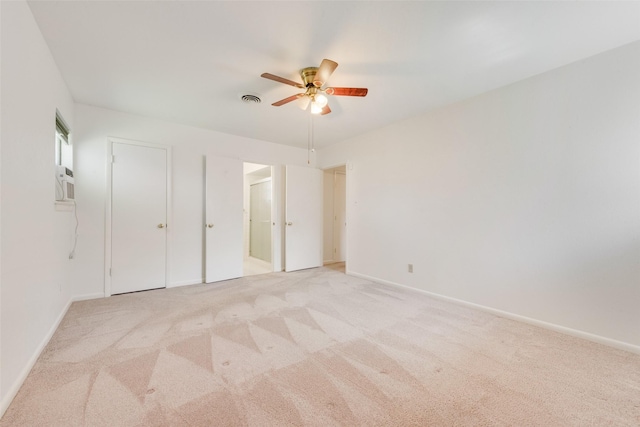 unfurnished bedroom with light colored carpet, visible vents, connected bathroom, ceiling fan, and baseboards