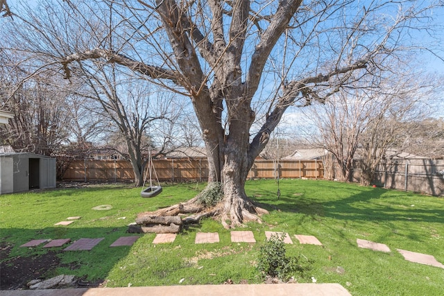 view of yard featuring a storage shed, a fenced backyard, and an outdoor structure