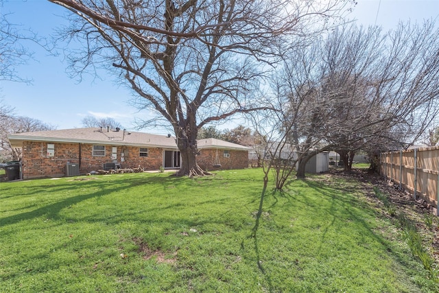 view of yard with a fenced backyard, an outdoor structure, a storage shed, and central air condition unit