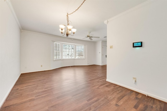 spare room with ornamental molding, wood finished floors, and baseboards