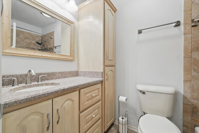 full bath featuring vanity, toilet, and tiled shower
