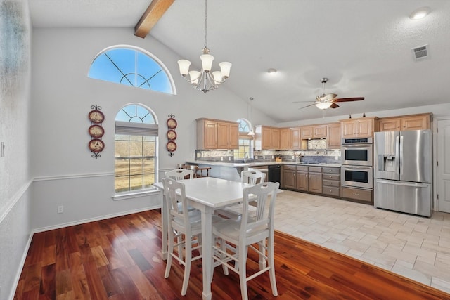 dining space with visible vents, beam ceiling, light wood-type flooring, high vaulted ceiling, and ceiling fan with notable chandelier