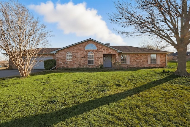 single story home featuring driveway, a front lawn, an attached garage, and brick siding