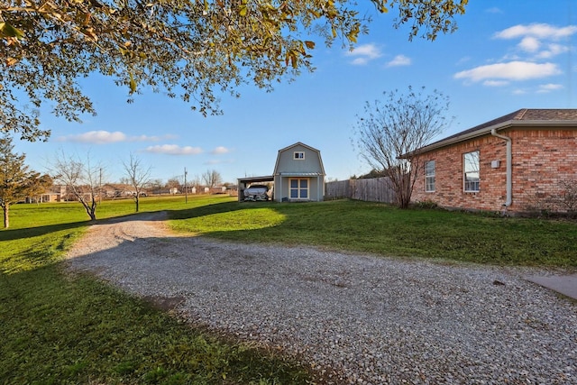 view of community featuring fence, driveway, and a yard