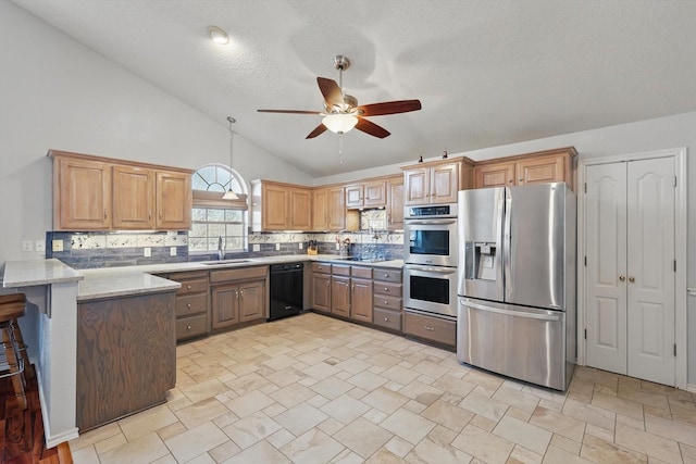kitchen featuring tasteful backsplash, appliances with stainless steel finishes, ceiling fan, a sink, and a peninsula