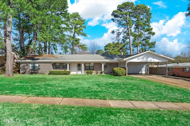 ranch-style home with brick siding, an attached carport, concrete driveway, and a front yard