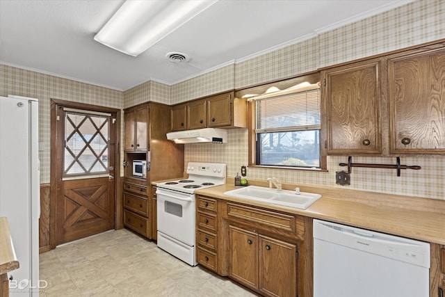 kitchen with white appliances, visible vents, light countertops, under cabinet range hood, and a sink