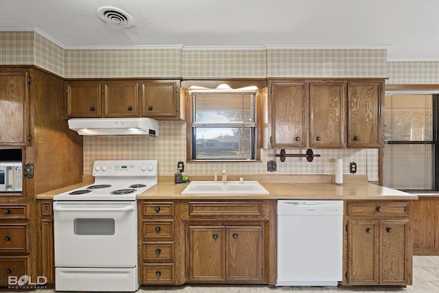 kitchen featuring white appliances, light countertops, a sink, and under cabinet range hood