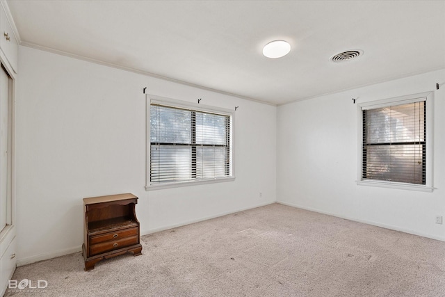 unfurnished room with ornamental molding, visible vents, light carpet, and baseboards