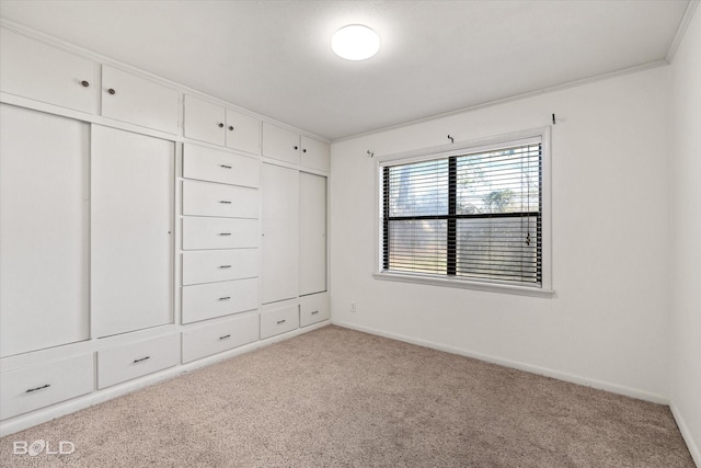 unfurnished bedroom with light carpet, crown molding, and baseboards