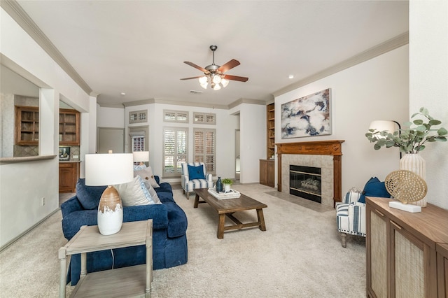 living room featuring light carpet, visible vents, a ceiling fan, a tiled fireplace, and ornamental molding