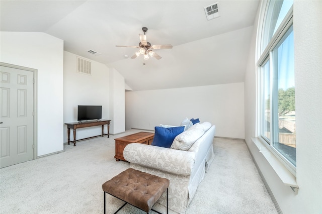 living area featuring vaulted ceiling, visible vents, and light colored carpet