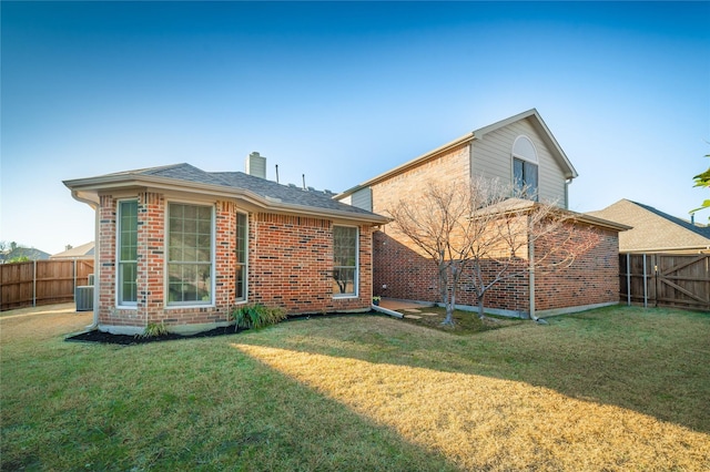 back of house with a yard, fence, central AC, and brick siding