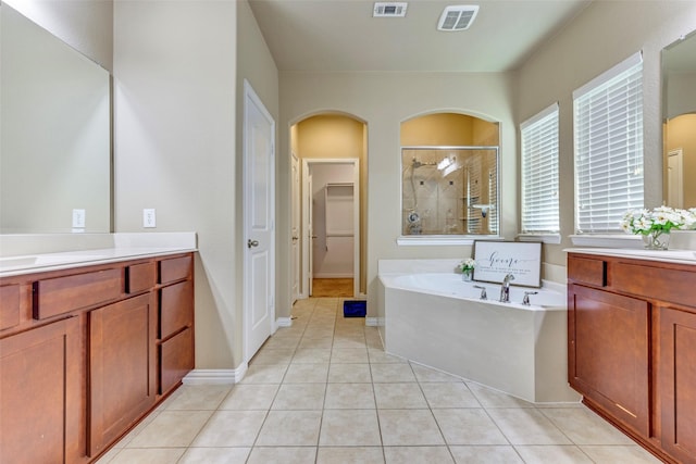 bathroom with a stall shower, vanity, a bath, and tile patterned floors