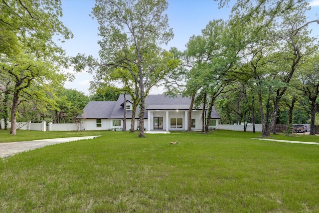 view of front of property featuring fence private yard and a front lawn