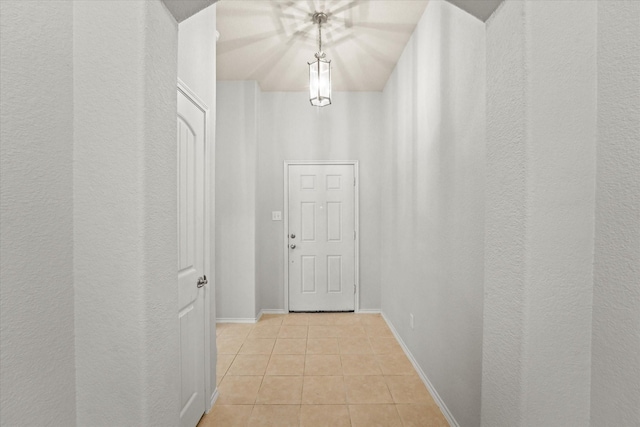 hallway with light tile patterned floors and baseboards