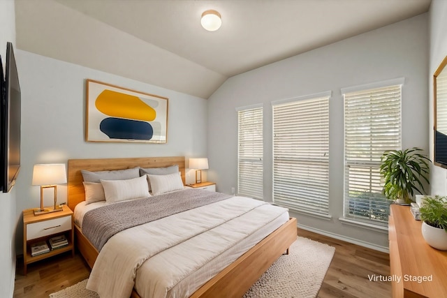 bedroom with lofted ceiling and light wood-style flooring