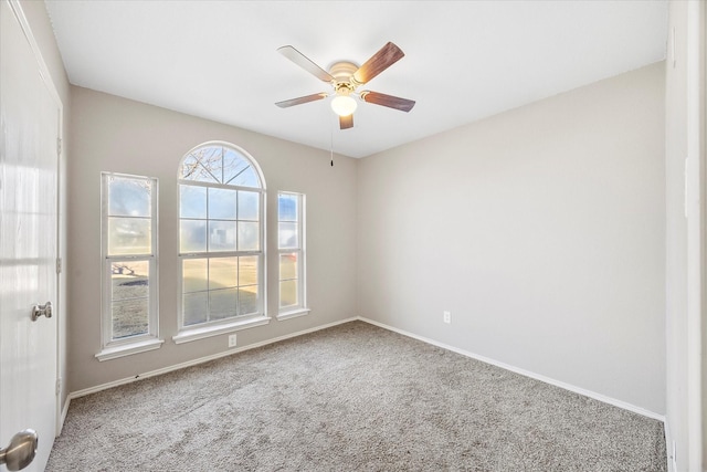 unfurnished room featuring carpet floors, ceiling fan, and baseboards