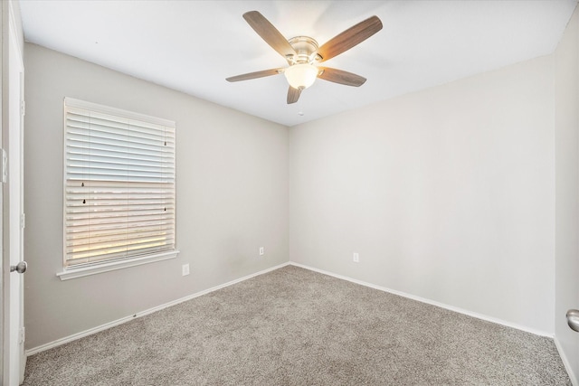 empty room with carpet floors, baseboards, and a ceiling fan