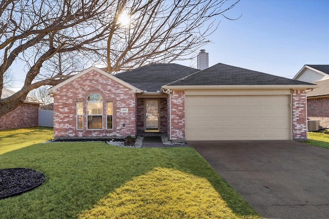 ranch-style house featuring central AC unit, an attached garage, concrete driveway, a front lawn, and a chimney