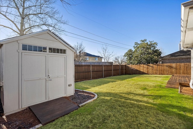 view of yard featuring an outbuilding, a shed, and a fenced backyard