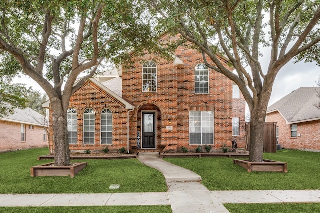 traditional-style home with a front lawn and brick siding