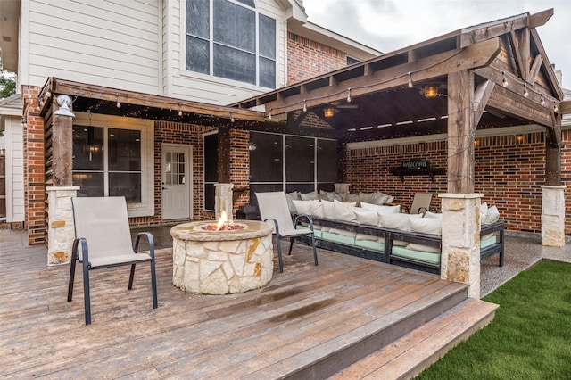 wooden terrace featuring an outdoor living space with a fire pit