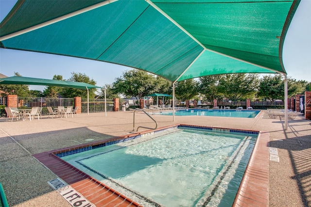 community pool featuring fence and a patio