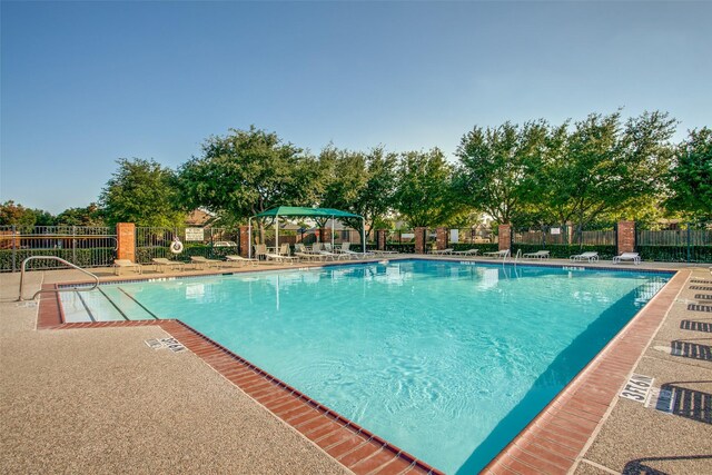 community pool featuring fence and a patio