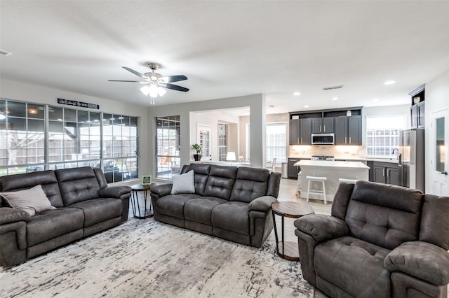 living area with ceiling fan, light wood-style flooring, visible vents, and recessed lighting