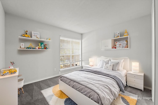 bedroom with dark carpet and baseboards