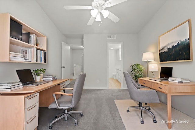 office space featuring a ceiling fan, visible vents, light carpet, and baseboards