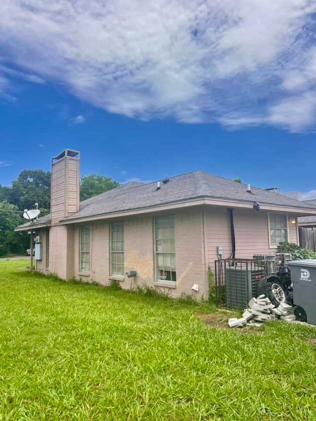 back of property featuring a lawn and a chimney