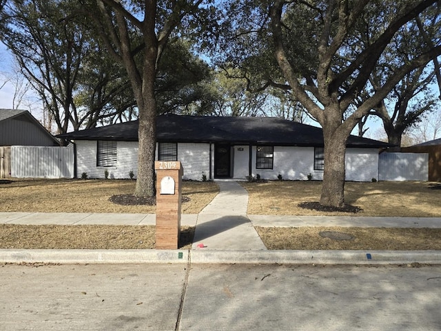 view of front of house featuring fence and brick siding